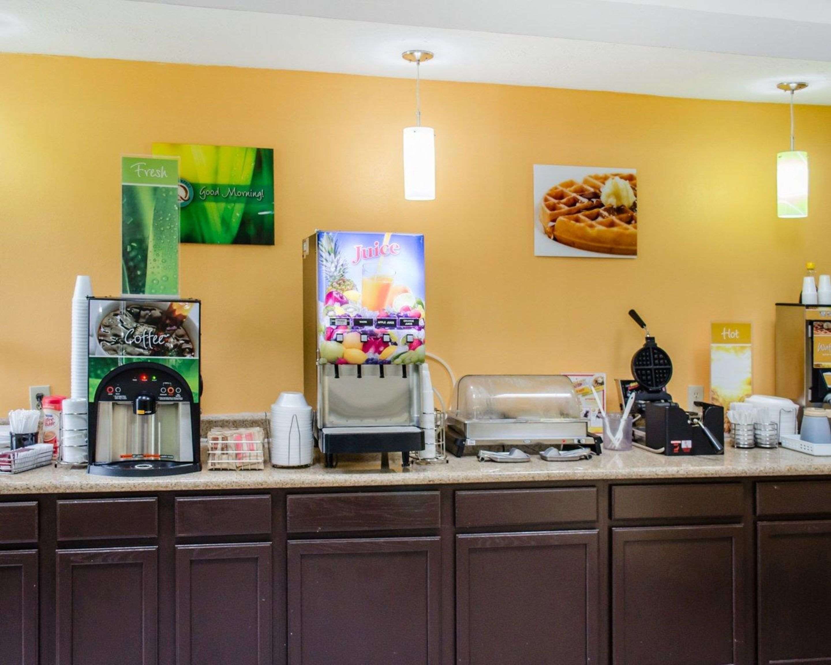 A coffee station with a coffee machine, a juice dispenser, and a waffle maker.