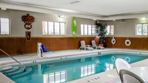 An indoor swimming pool with a diving board, lounge chairs, and a lifebuoy. - Quality Inn & Suites Medina - Akron West (Medina)
