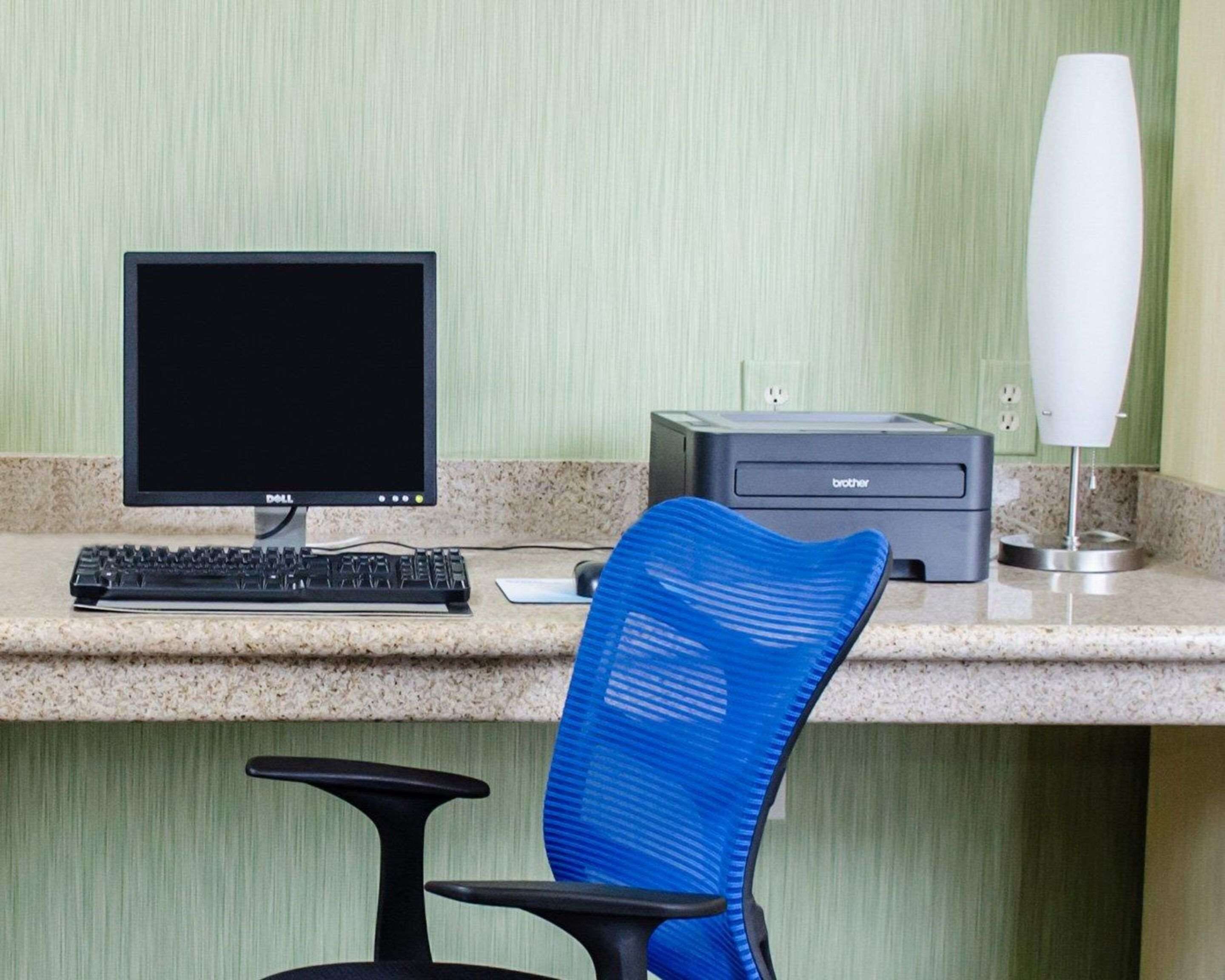 Ein Schreibtisch mit Computer, Tastatur und Drucker.