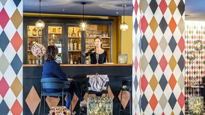 Zona de bar con mostrador, taburetes y objetos decorativos.