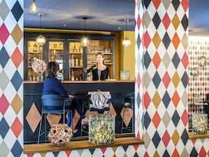 Eine Bar mit Theke, Hockstühlen und Dekoration.