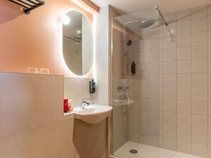 A modern bathroom with a glass-enclosed shower, a sink, and a mirror. - ibis Styles Reims Centre Cathédrale (Reims)
