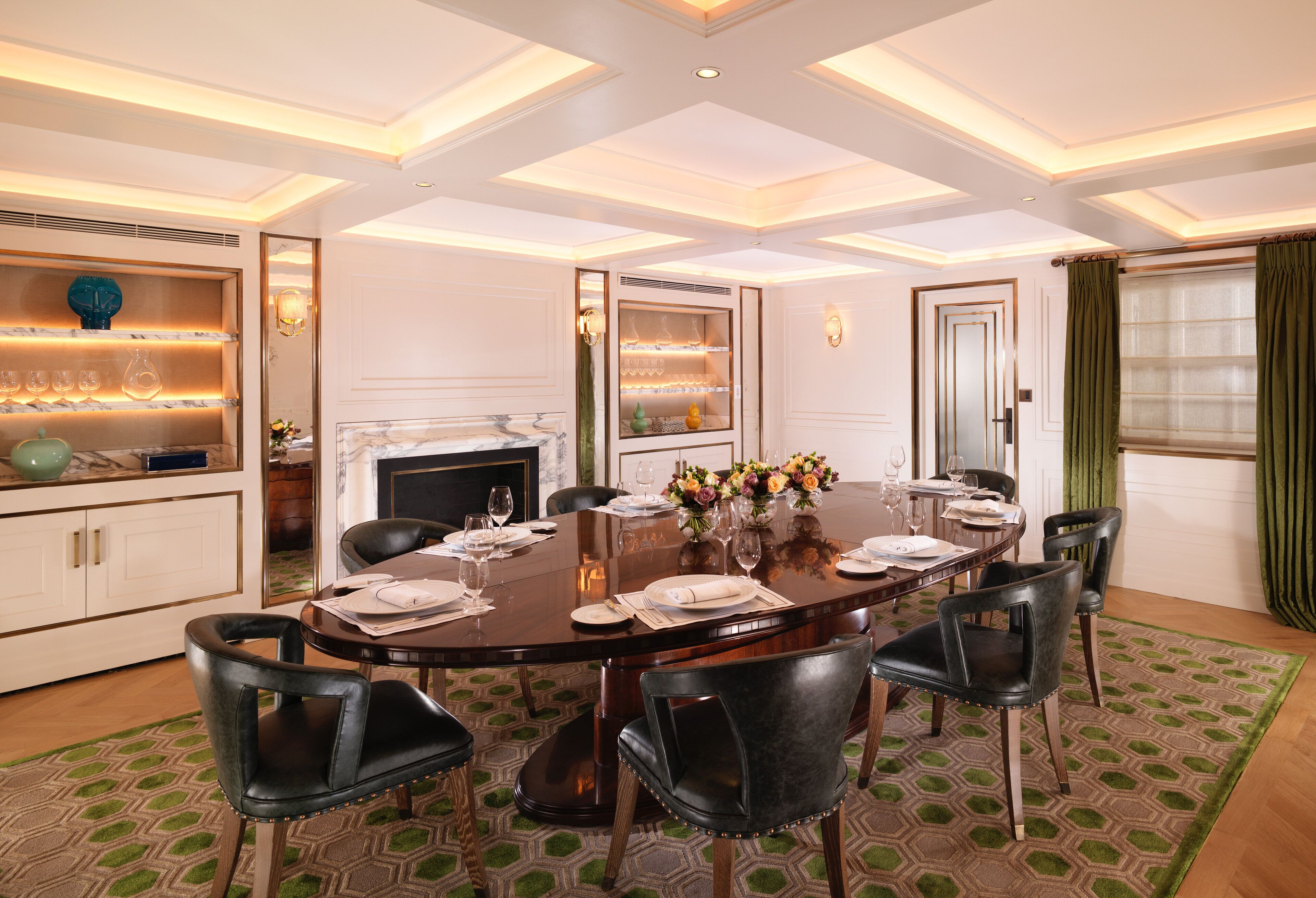 A dining area with a round table, six chairs, and a chandelier.
