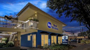 A Best Western hotel with a blue facade, a wheelchair-accessible entrance, and a parking sign. - Best Western University Lodge (Davis)