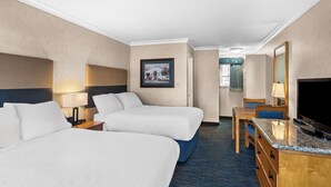 A hotel room with two beds, a desk, a television, and a framed picture on the wall. - Best Western University Lodge (Davis)