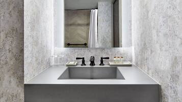 A bathroom with a large mirror, a rectangular sink, and a shower curtain.