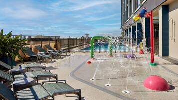 Relax by the pool, surrounded by soothing water features and lounge chairs.