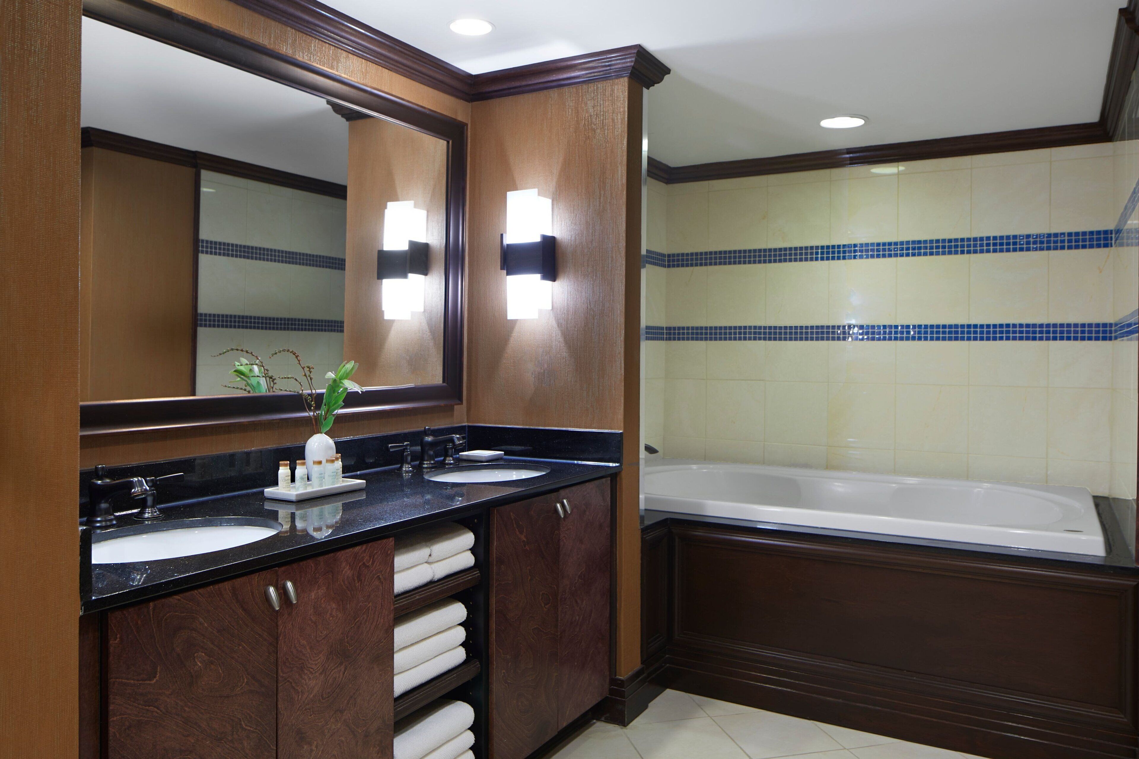 Un baño con dos lavabos, un espejo grande y una bañera.