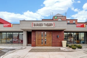 A Burger Theory restaurant with a Holiday Inn sign above it.