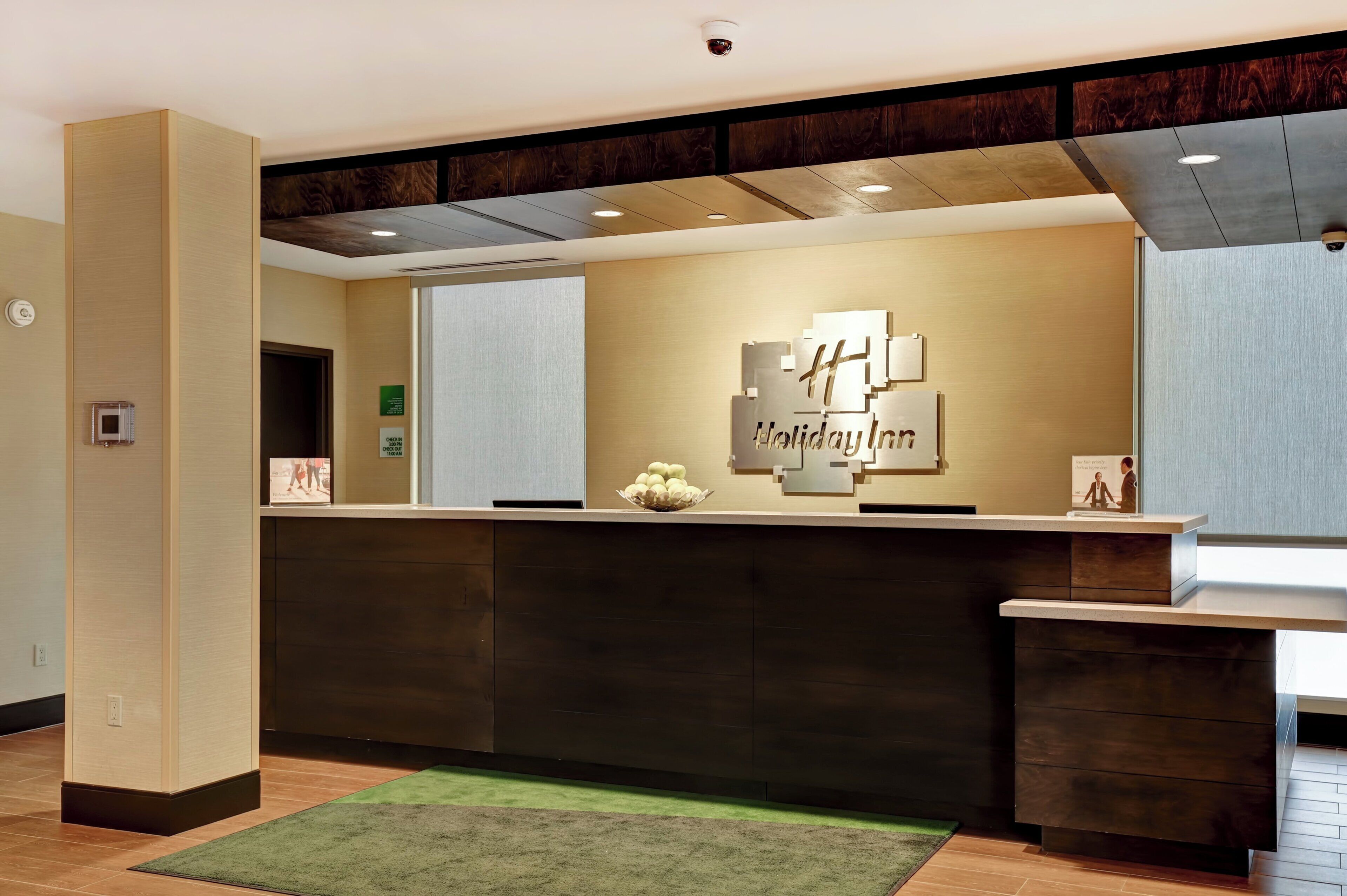 A reception desk with a modern design, a check-in counter, and a wall-mounted sign.