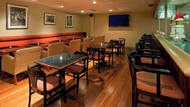 A restaurant with booths, tables, and chairs. There are framed pictures on the walls. - Holiday Inn Mississauga Toronto West by IHG (Mississauga)