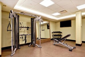A gym with various exercise equipment, including a squat rack, bench press, and dumbbells. - Holiday Inn Mississauga Toronto West by IHG (Mississauga)