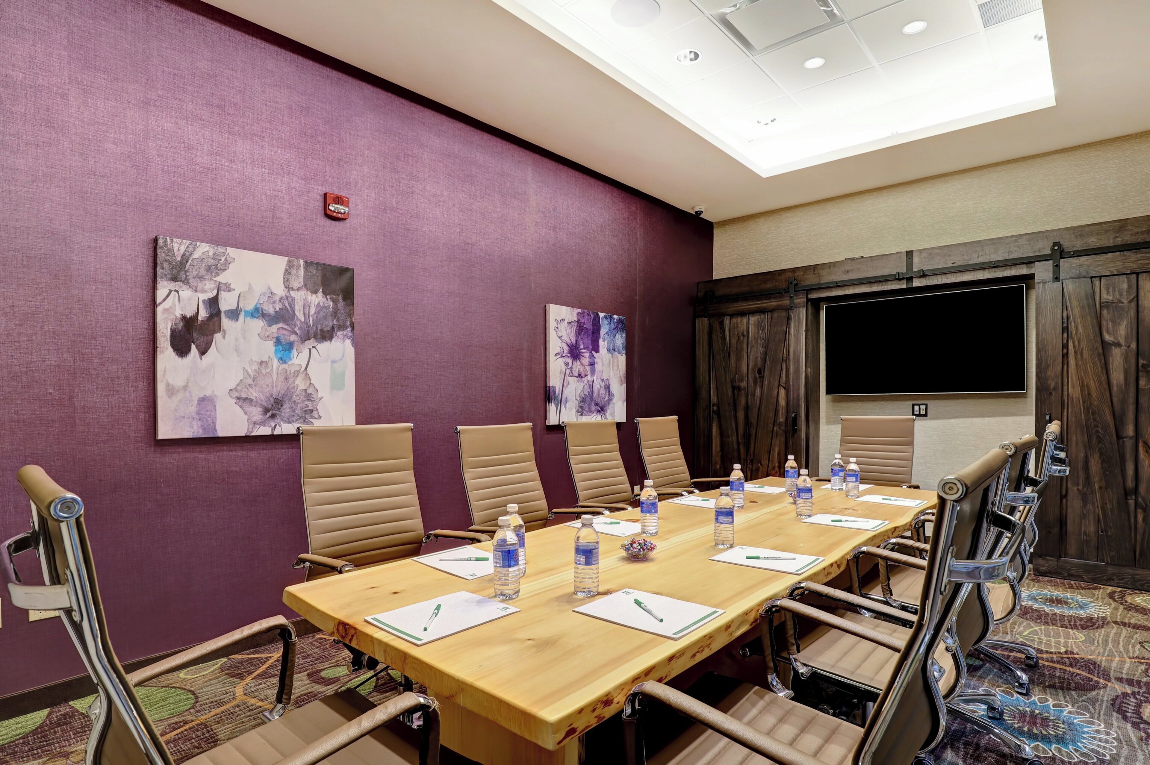 A conference room with a long table, chairs, water bottles, and nameplates.