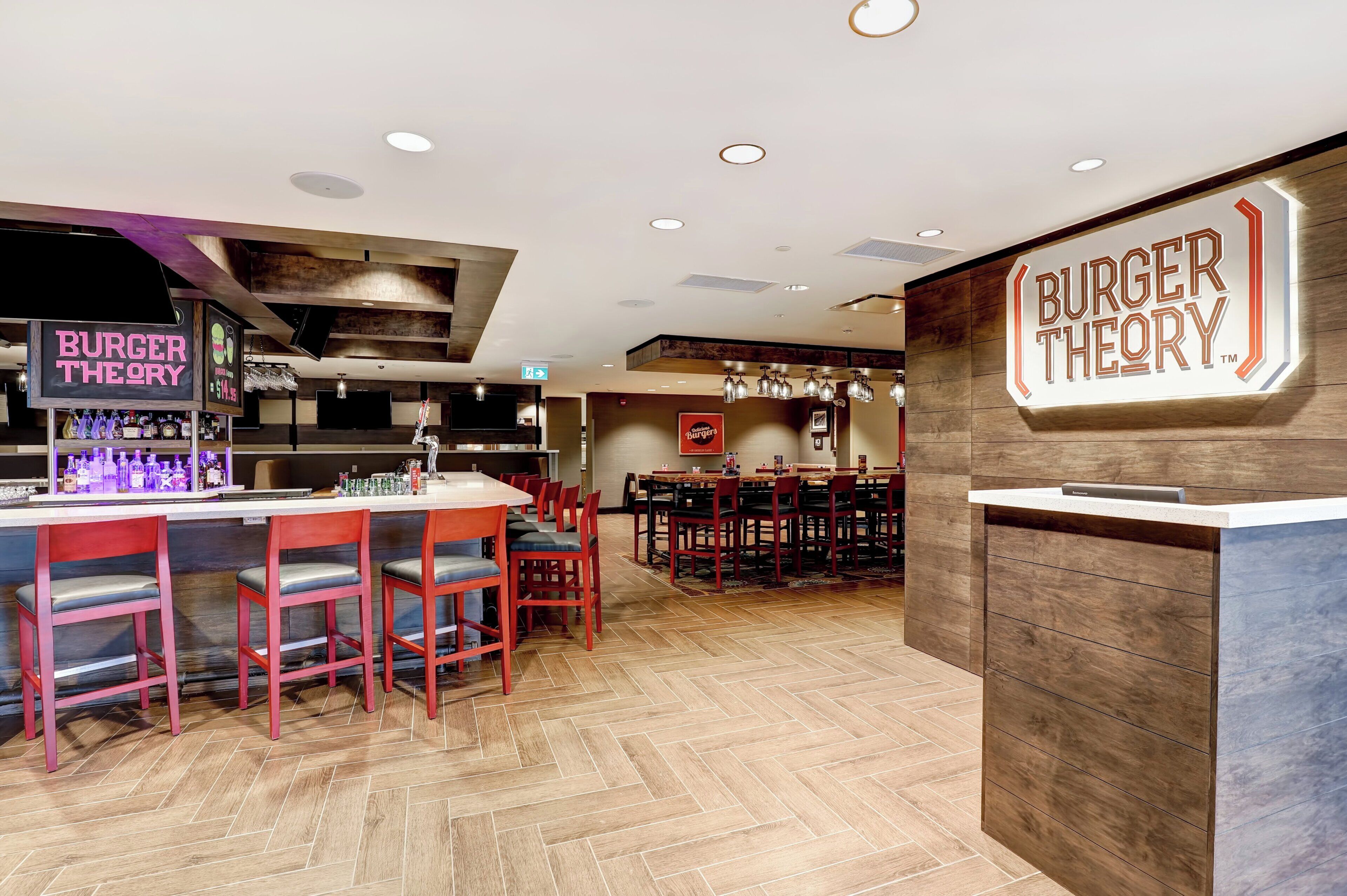 Ein Restaurantinneres mit Barbereich, Holzböden und einer Rezeption.