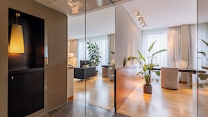 Un moderno vestíbulo de hotel con mostrador de recepción, zona de estar y ventanas amplias.