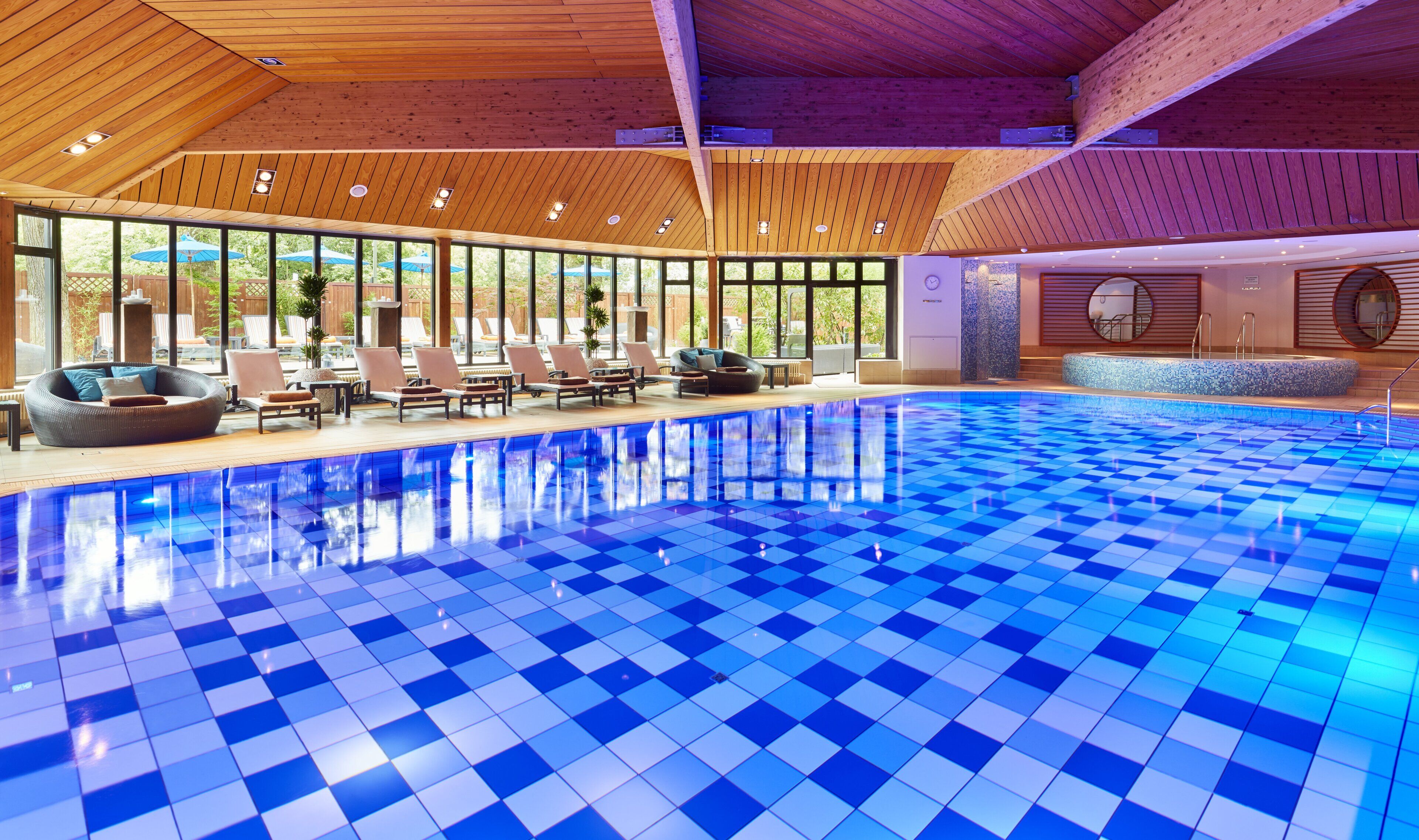 Una piscina techada, sillones reclinables de piscina