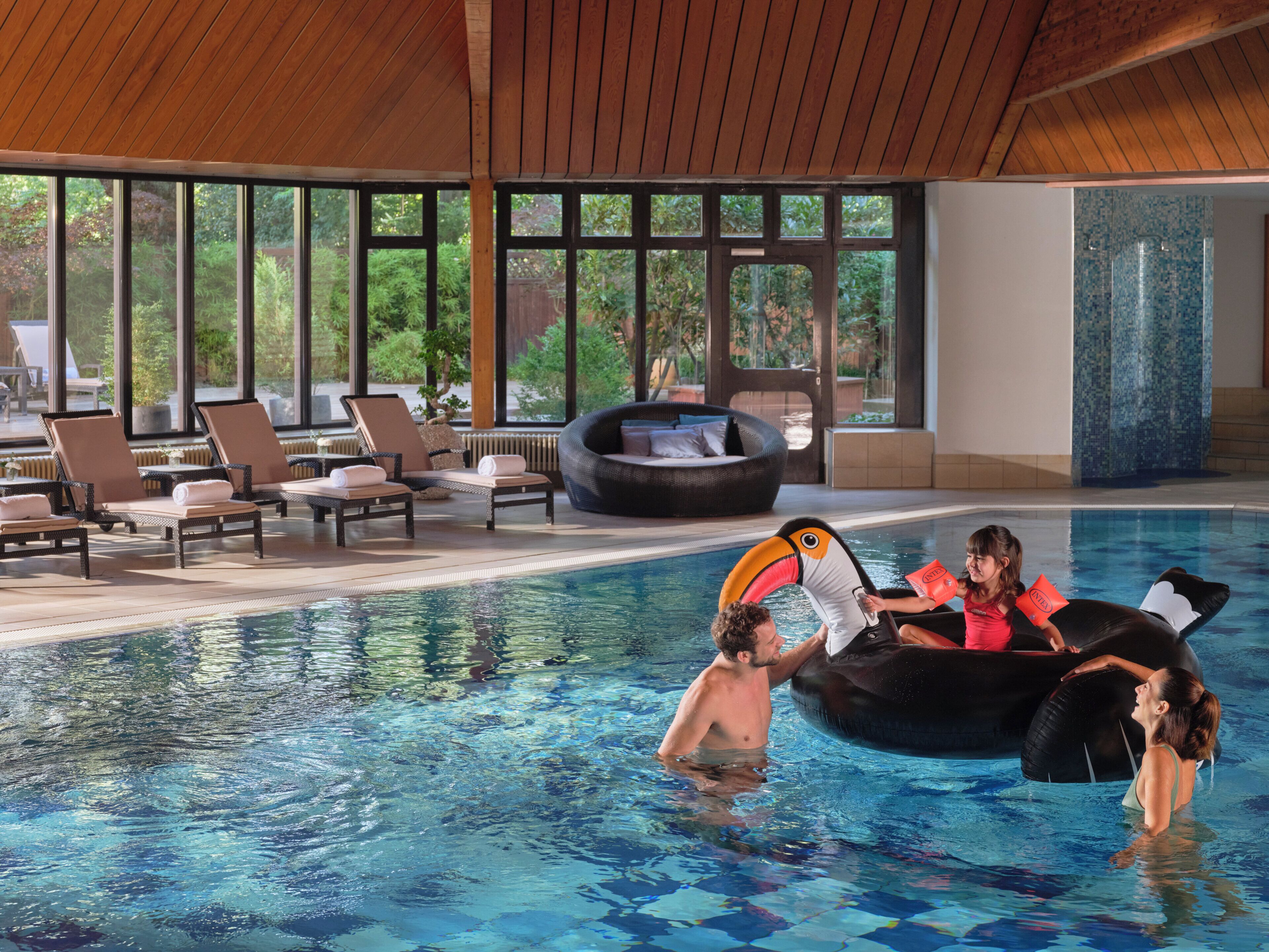 A swimming pool with lounge chairs and a hot tub.