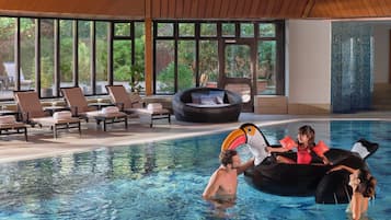 A swimming pool with lounge chairs and a hot tub.