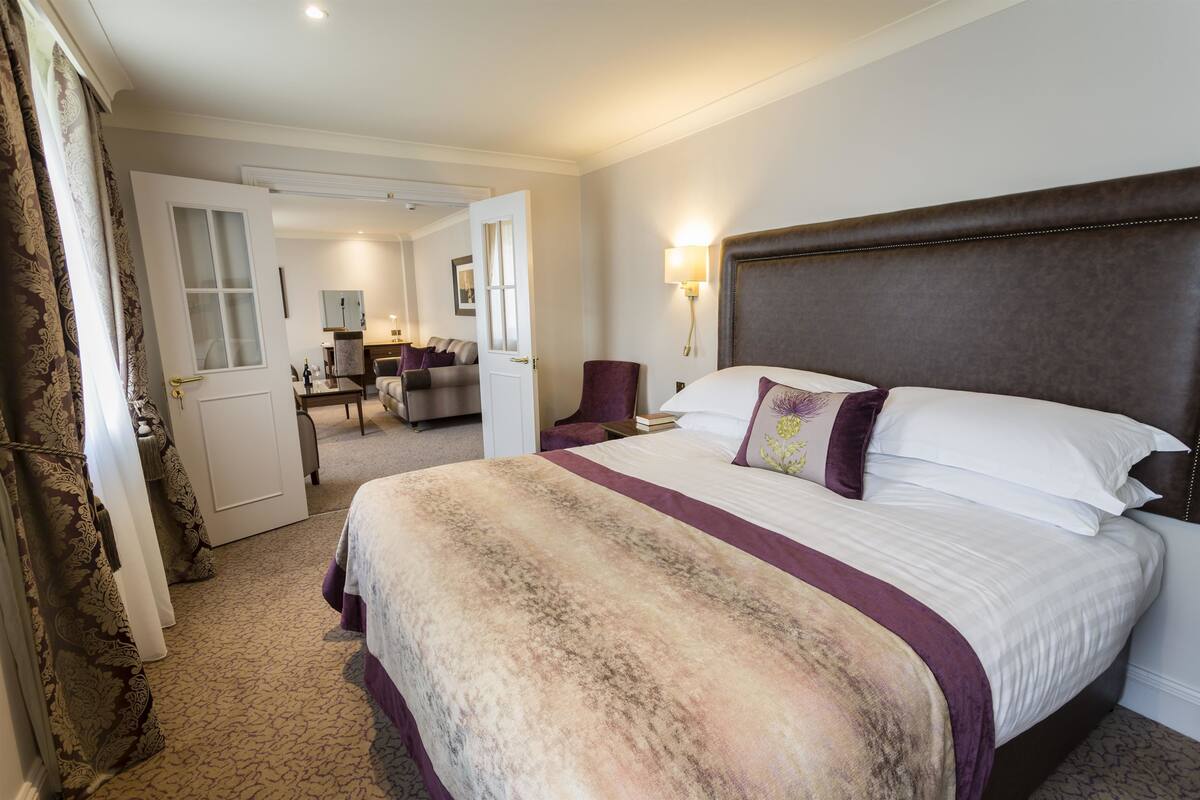 Een hotelkamer met een groot bed, een bureau en een stoel.