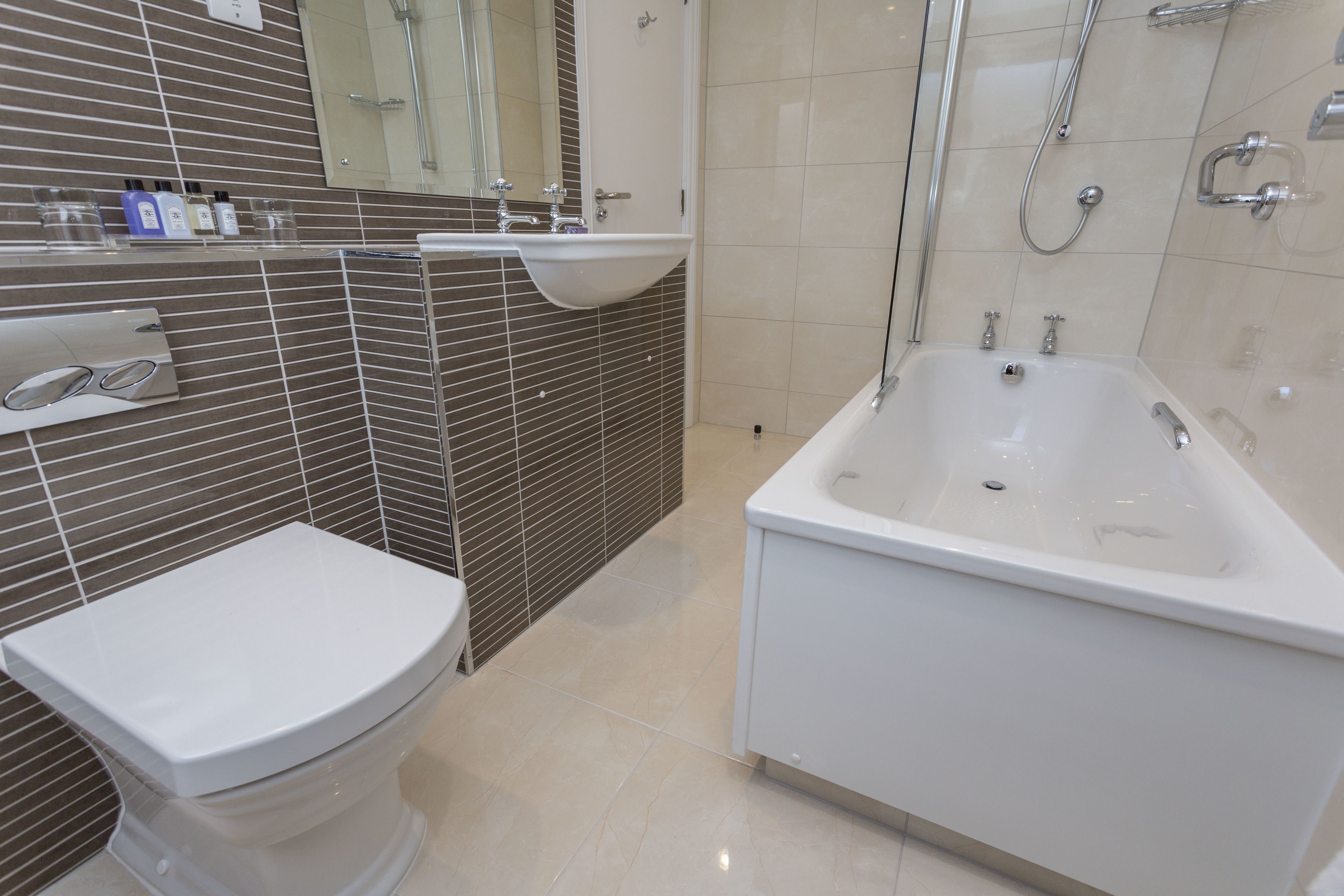 A modern bathroom with a toilet, sink, and bathtub.