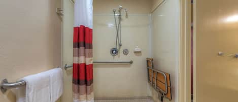 A shower area with a glass door, a towel rack, and a shower control panel.