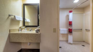 A bathroom with a sink, mirror, towel rack, and shower curtain.