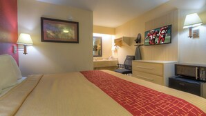 A hotel room with a bed, a desk, a chair, a TV, and a microwave. - Red Roof Inn Memphis East (Memphis)
