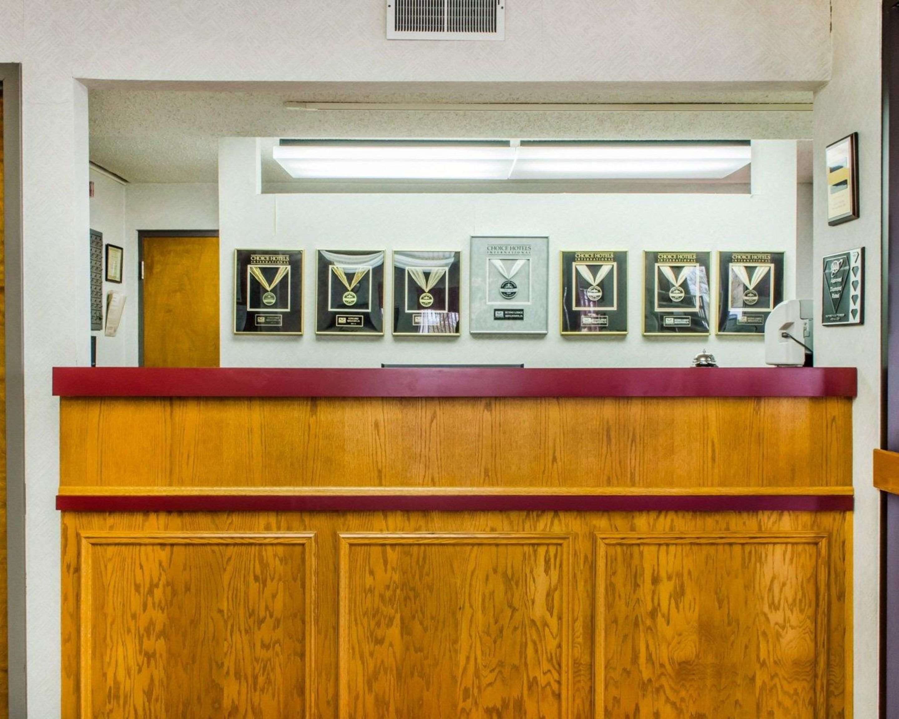 A reception desk with framed awards on the wall above.