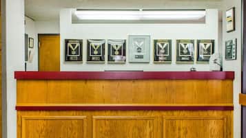 A reception desk with framed awards on the wall above.