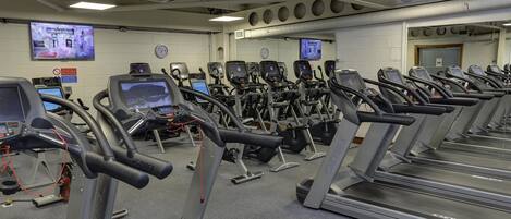 A gym with multiple treadmills, exercise bikes, and cardio machines.