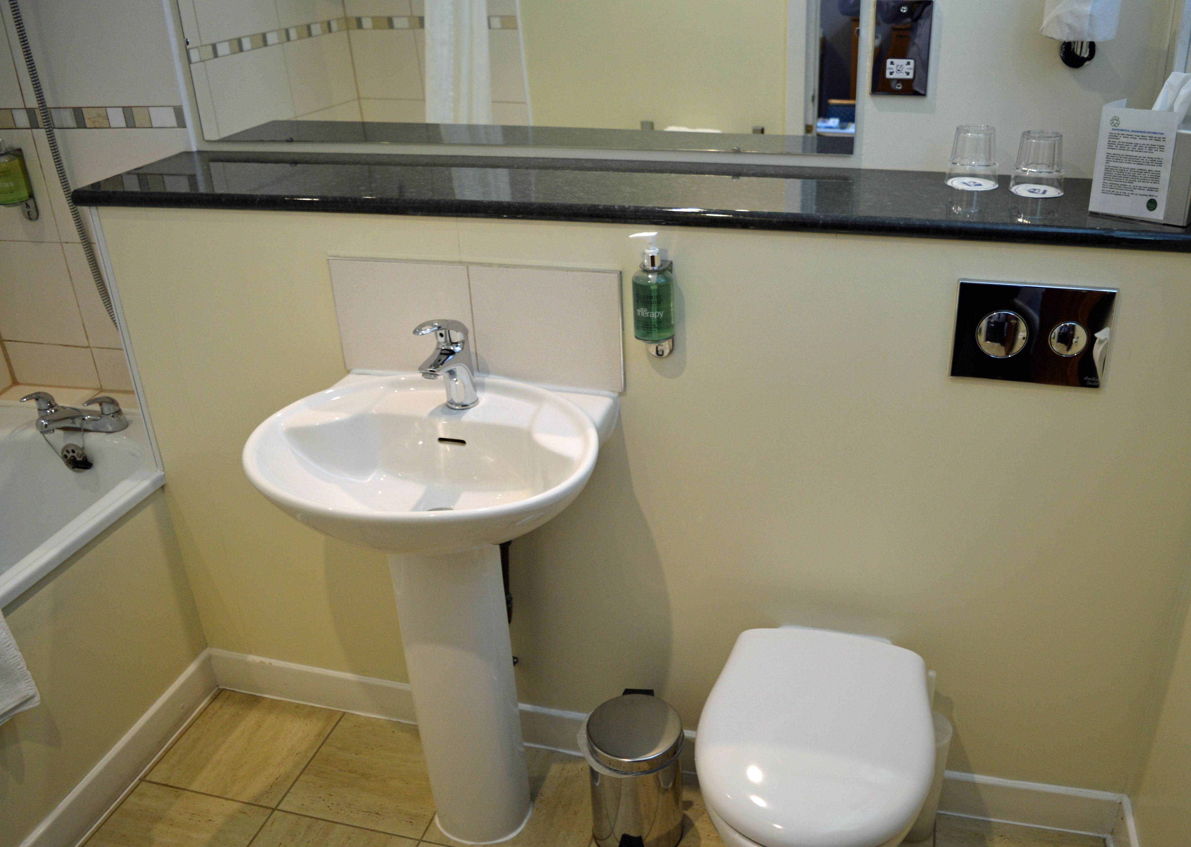 Un baño con un lavamanos blanco, un inodoro y una bañera.