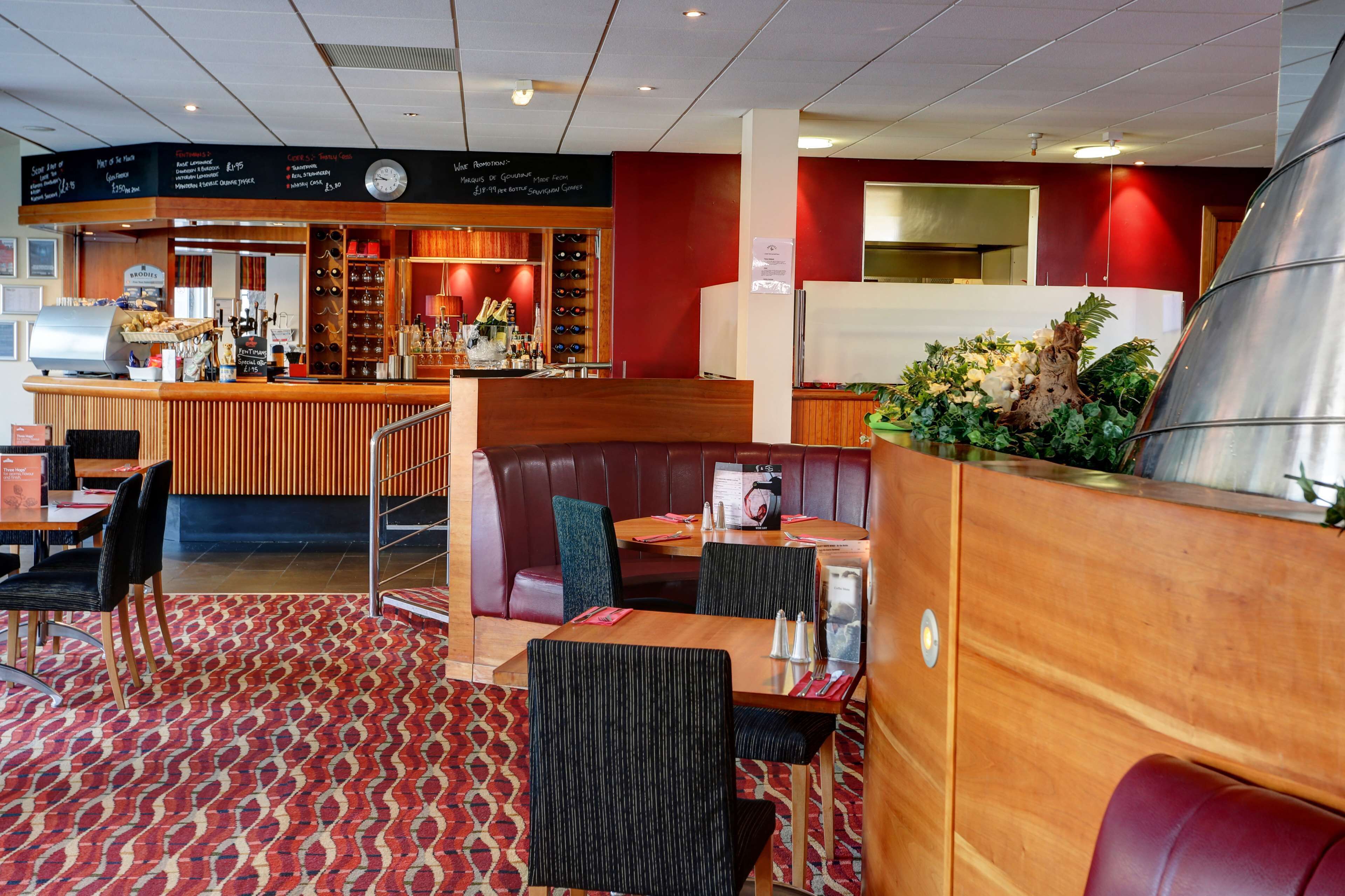 A restaurant with booths, a bar area, and a menu board.