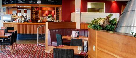 A restaurant with booths, a bar area, and a menu board.