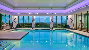 A swimming pool with a view of the landscape through large windows. - Holiday Inn Express & Suites VA Beach Oceanfront by IHG (Virginia Beach)