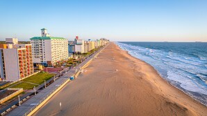 A beachfront hotel with a long promenade, a clock tower, and a view of the ocean. - Holiday Inn Express & Suites VA Beach Oceanfront by IHG (Virginia Beach)