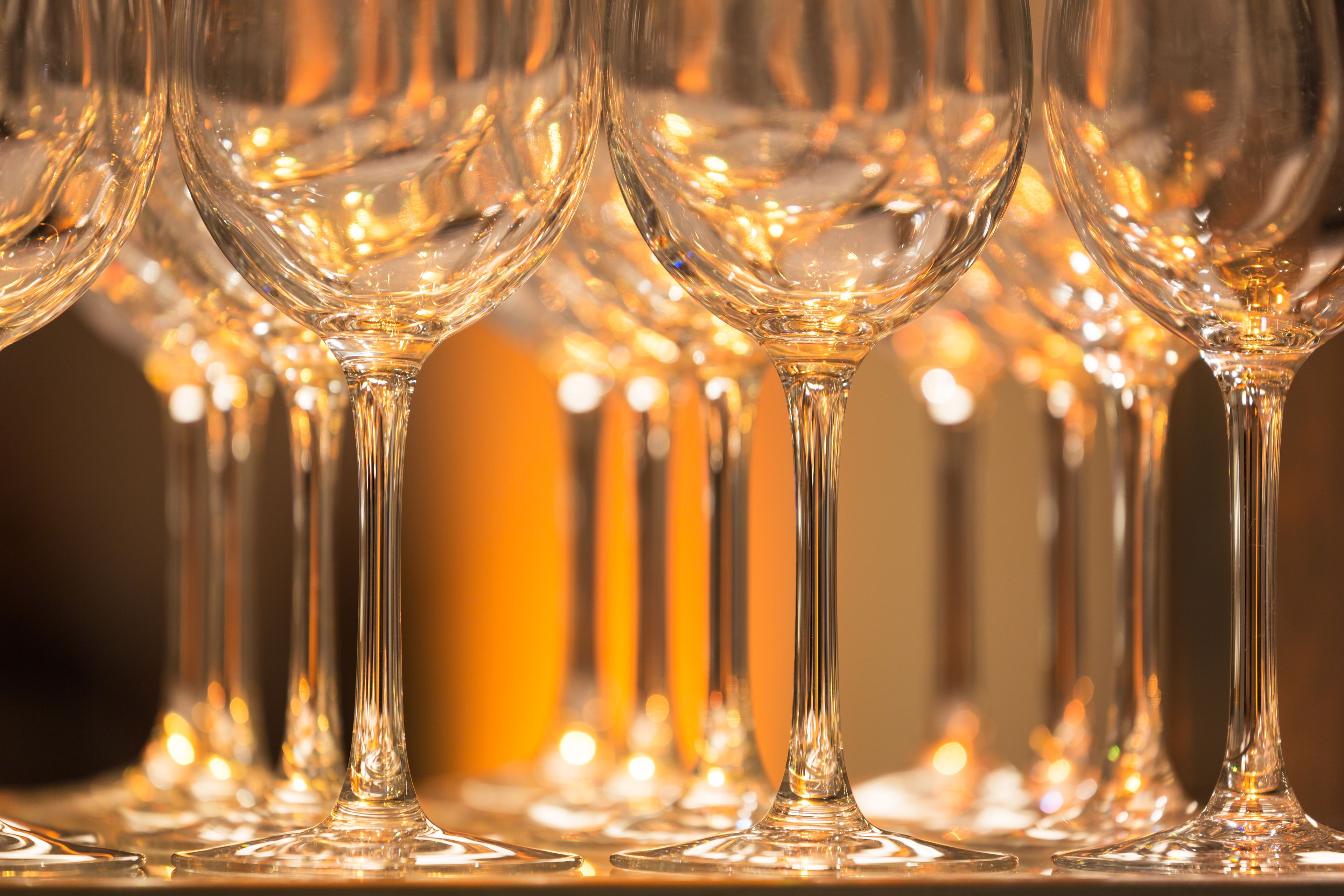 Una fila de copas de vino vacías sobre una mesa.