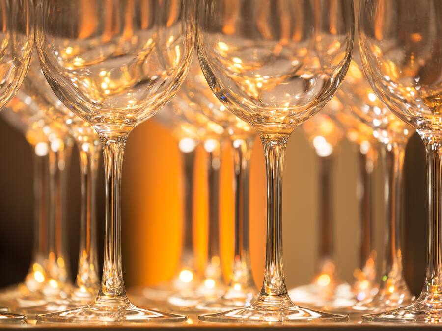 Una fila de copas de vino vacías sobre una mesa.