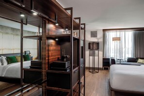 A modern hotel room with a large bed, a desk with a computer, a wardrobe, and a mirror. - North Charleston Marriott (North Charleston)