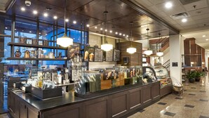 Een moderne koffiebar met een toonbank, espresso machines en een menubord.