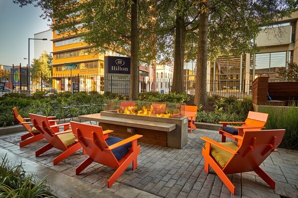 A hotel with outdoor seating and a fire feature.