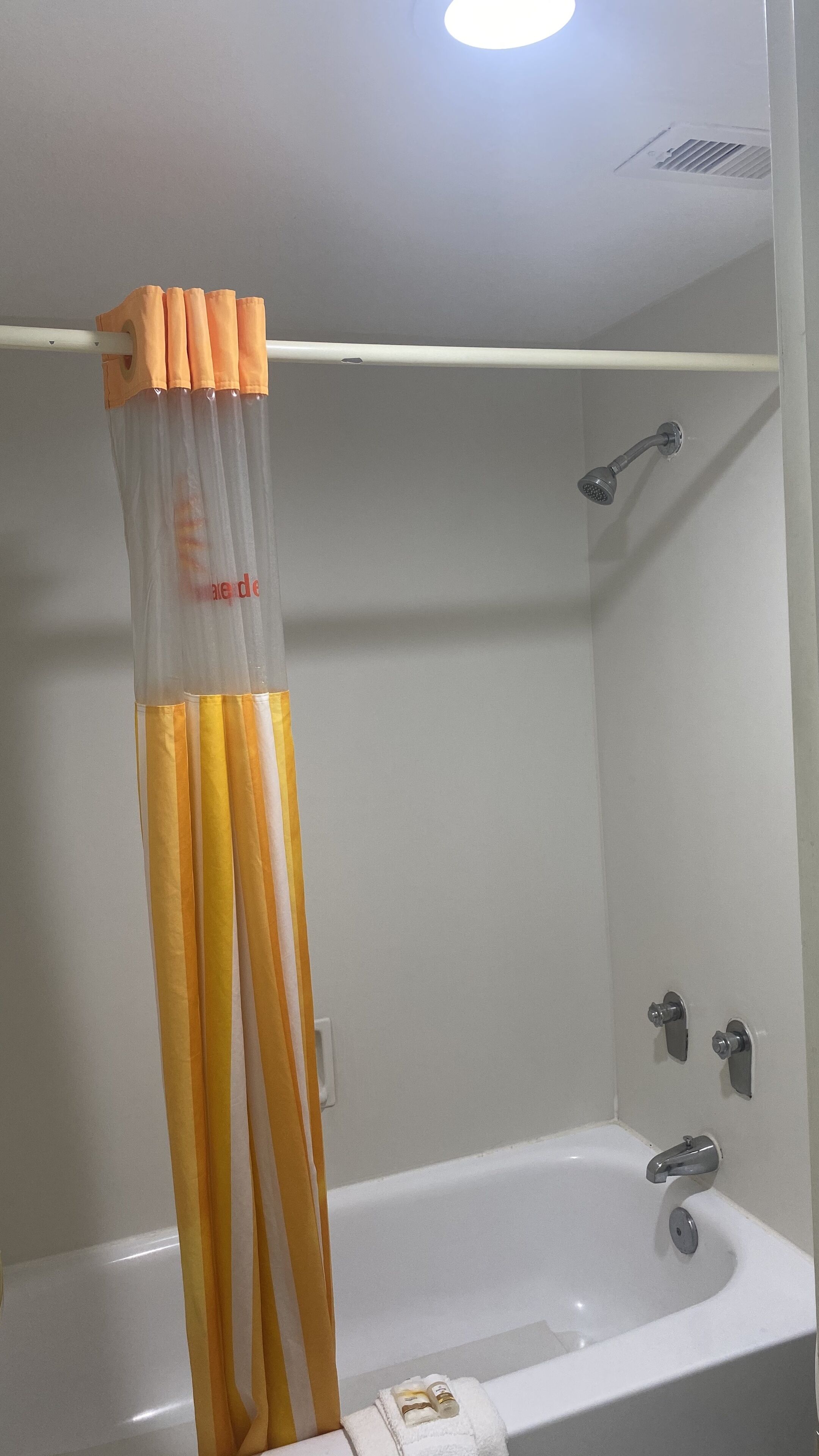 Un baño con una bañera, cortina de ducha y toallero.