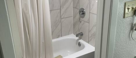 Un bagno con una vasca, un water e una tenda da doccia.