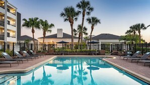 A swimming pool with lounge chairs and palm trees. - Courtyard by Marriott Tampa Westshore/Airport (Tampa)