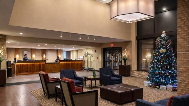 A lobby with a reception desk, seating area, and a Christmas tree. - Comfort Inn  Farmington Hills - Detroit Northwest (Farmington Hills)
