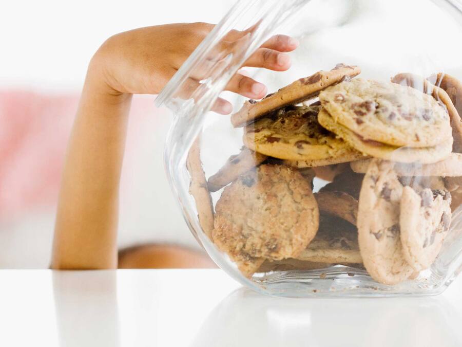 A clear glass container filled with cookies.