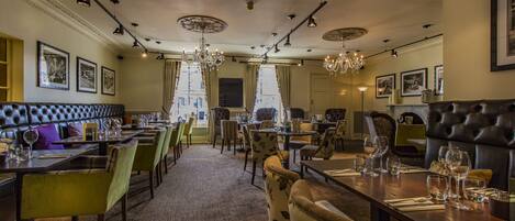 Un restaurante con una larga mesa de comedor, varias sillas y un candelabro.