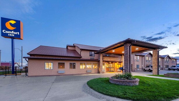 A Comfort Inn hotel with a modern design, featuring a well-lit entrance and a landscaped area with a small garden.