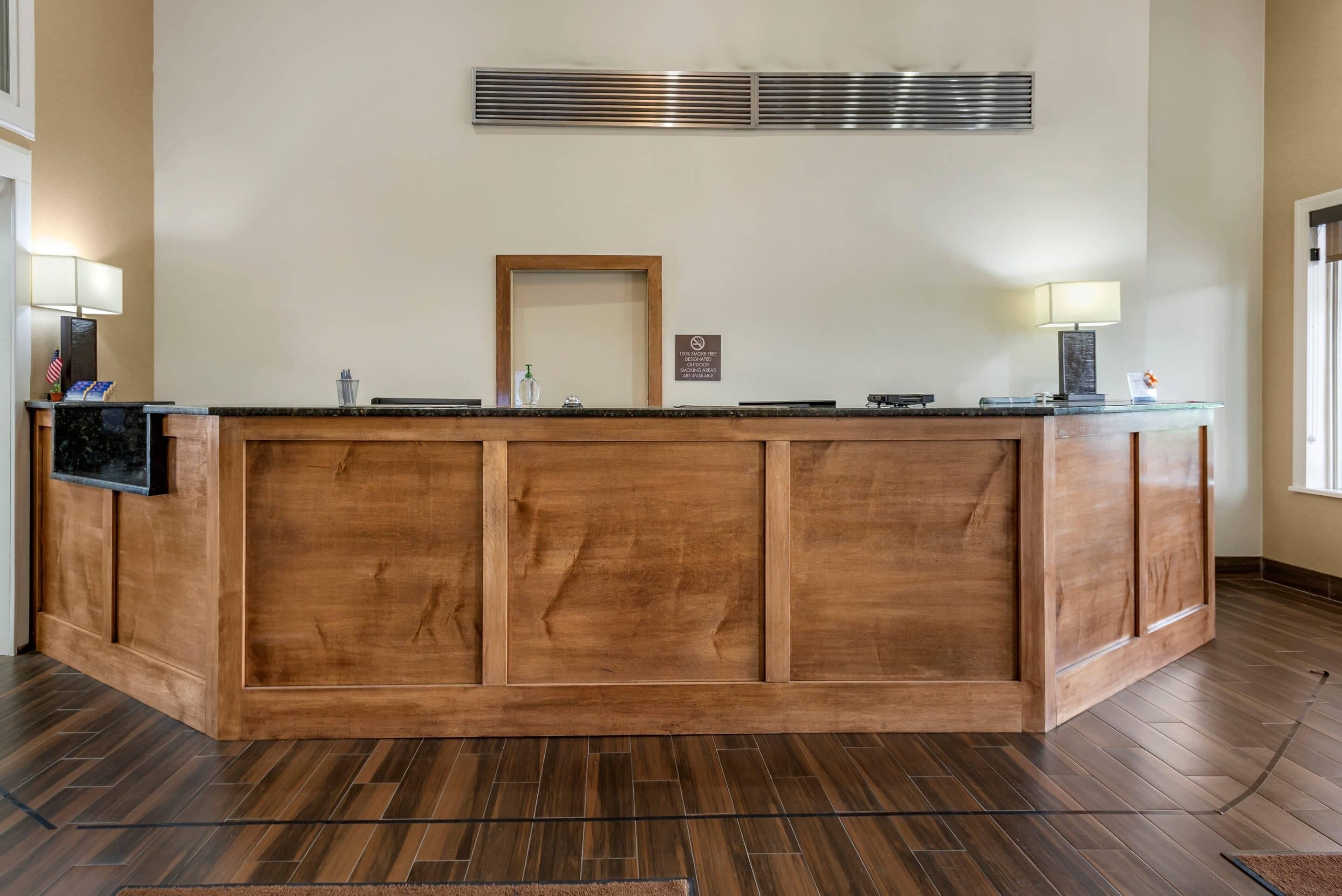 Una recepción con encimera de madera, un televisor de pantalla plana y un espejo enmarcado en la parte superior.