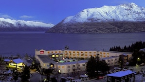 A hotel with multiple floors, a swimming pool, and a view of snow-capped mountains. - Mercure Queenstown Resort (Queenstown)