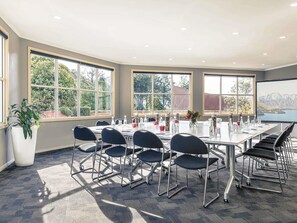 A conference room with a large table, chairs, and windows with a view. - Mercure Queenstown Resort (Queenstown)